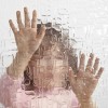 girl looks through clouded glass wall