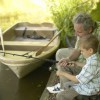 Boy (6-8) and grandfather fishing from side of lake