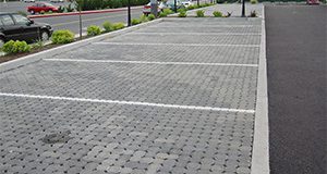 Newly installed PICP parking stalls as part of a commercial installation. Note the curb separating landscaping and directing runoff away from the pavement surface.