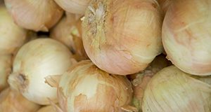 Photo of a pile of yellow onions.